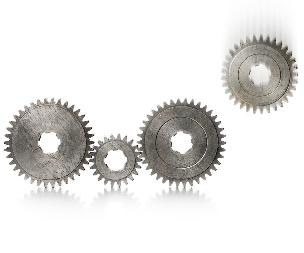 Ein Zahnrad wird aus einer Kette von Zahnrädern entfernt. Ein Symbolbild für die Ausgliederung von Unternehmenseinheiten bei der Spin-off Unternehmensvermittlung. 