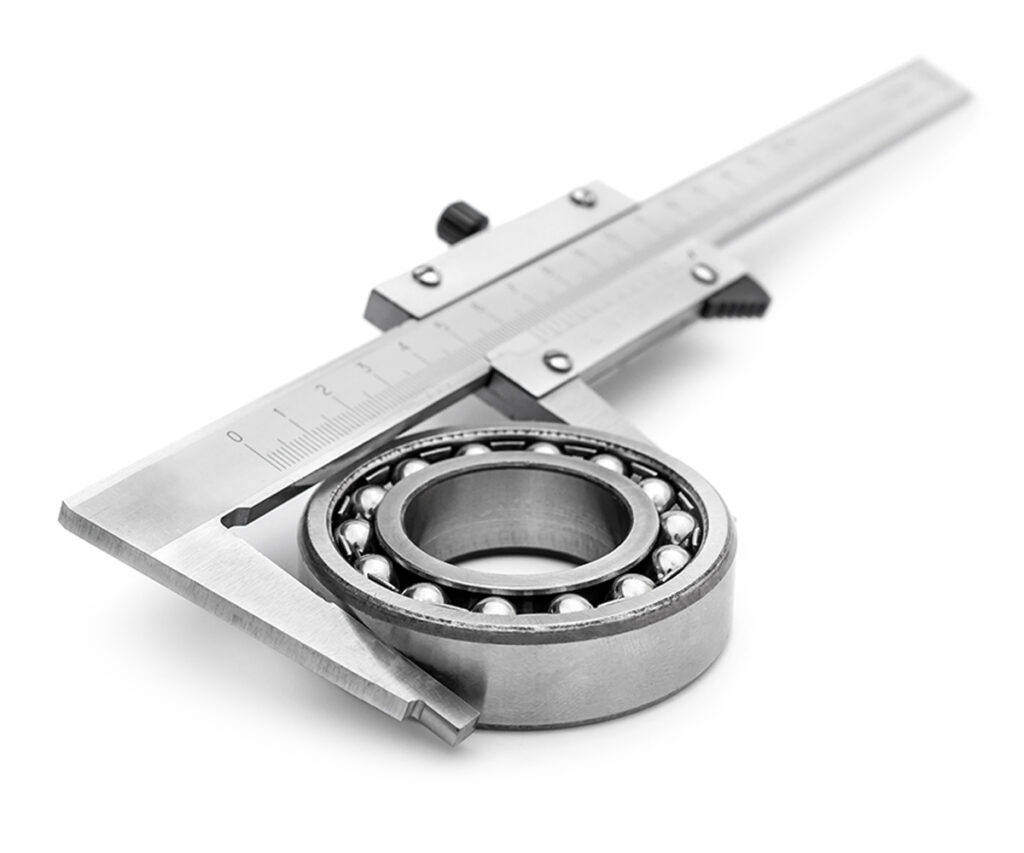 Ein Messschieber wird zum Vermessen eines gefertigten Metallteils genutzt. 